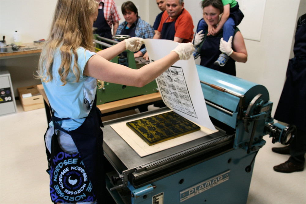 Mädchen mit Druckstock bei der Kartenherstellung in der Kartenmacherwerkstatt