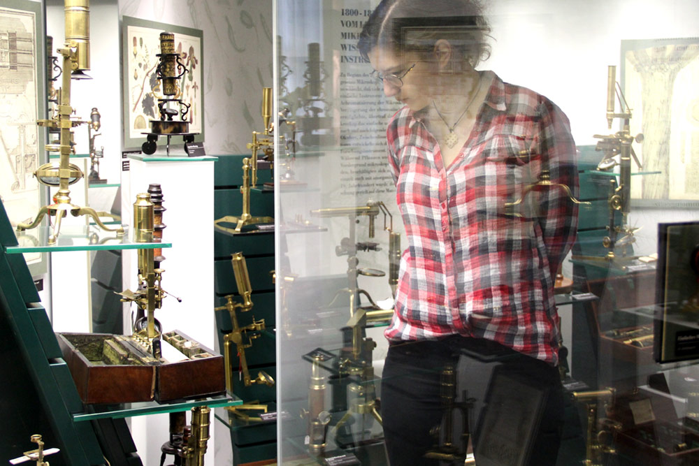 Besucherin im Ausstellungsraum mit Mikroskopen im Optischen Museum Jena